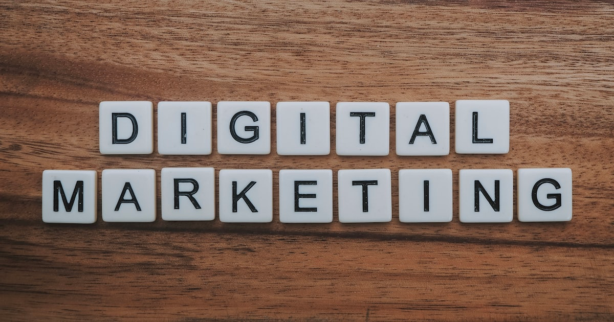 White letter tiles spell out DIGITAL MARKETING on a wooden surface, arranged in two horizontal rows—perfectly capturing the focus of a full service marketing agency that delivers everything from content marketing packages to website maintenance.